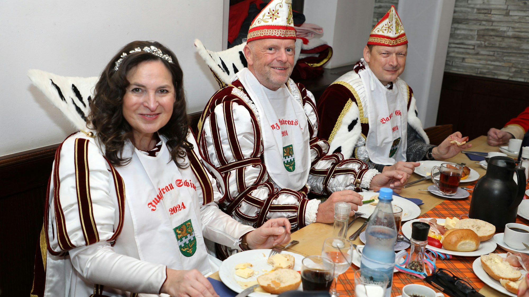 Jungfrau Sabine, Prinz Andreas I. und Bauer Gerd sitzen an einem Tisch in der Hofburg Lindenhof in Moitzfeld beim Frühstück.