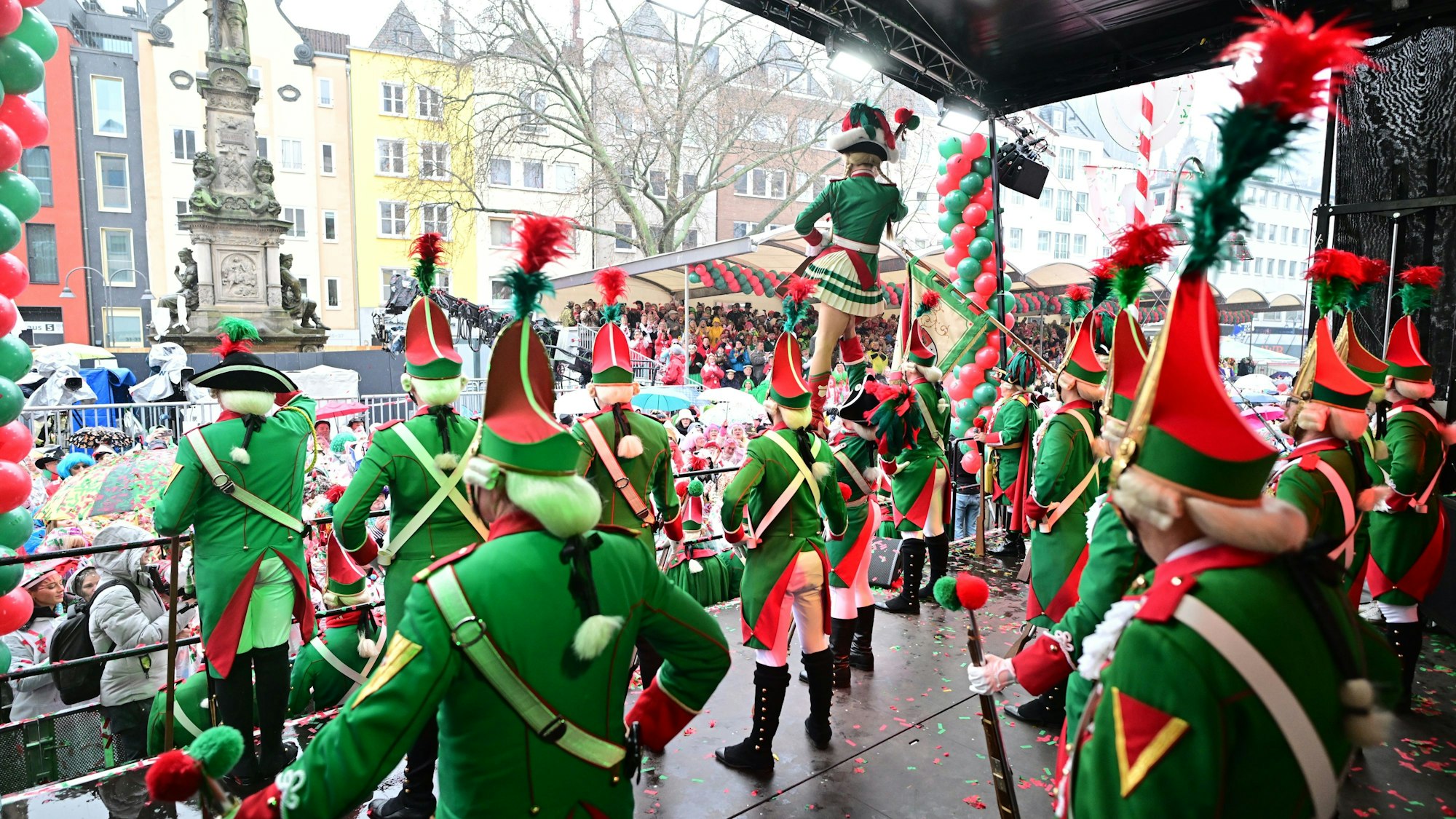 Menschen in rot-grünen Uniformen auf der Bühne.