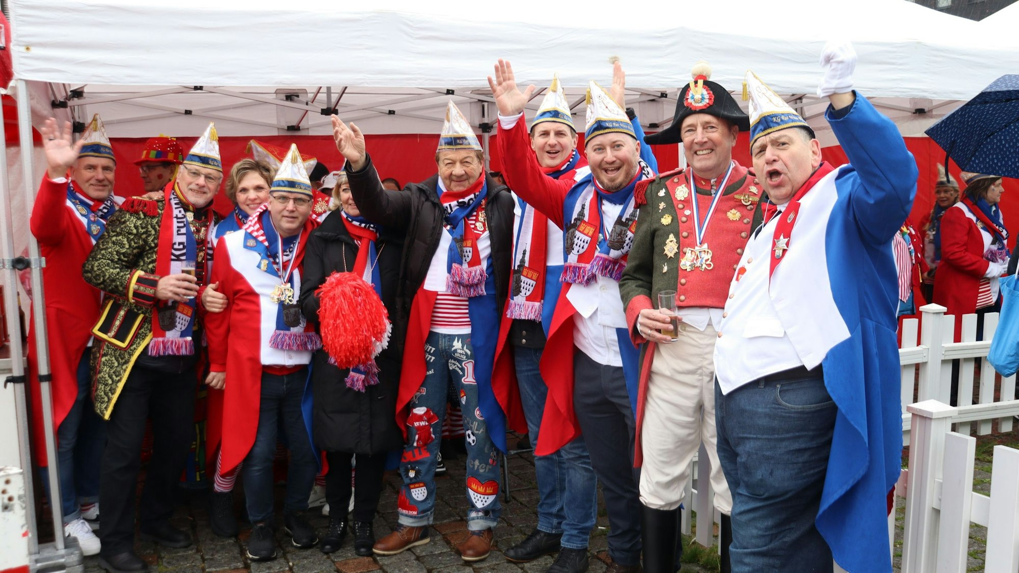 Männer in Karnevalsuniformen stehen zusammen.