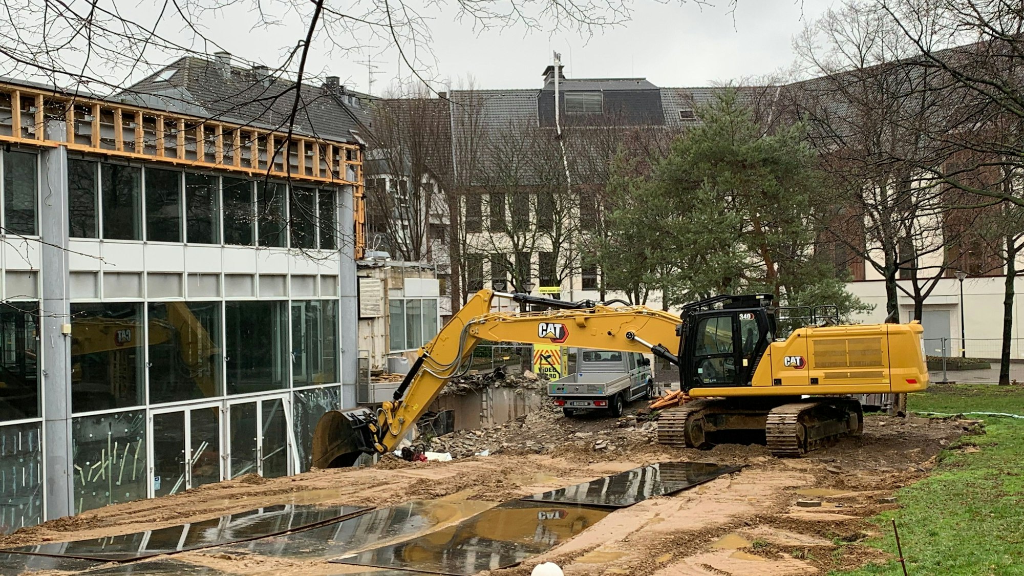 Ein Abrissbagger steht vor dem City-Forum. Erste Teile des Gebäudes sind bereits abgebrochen worden.