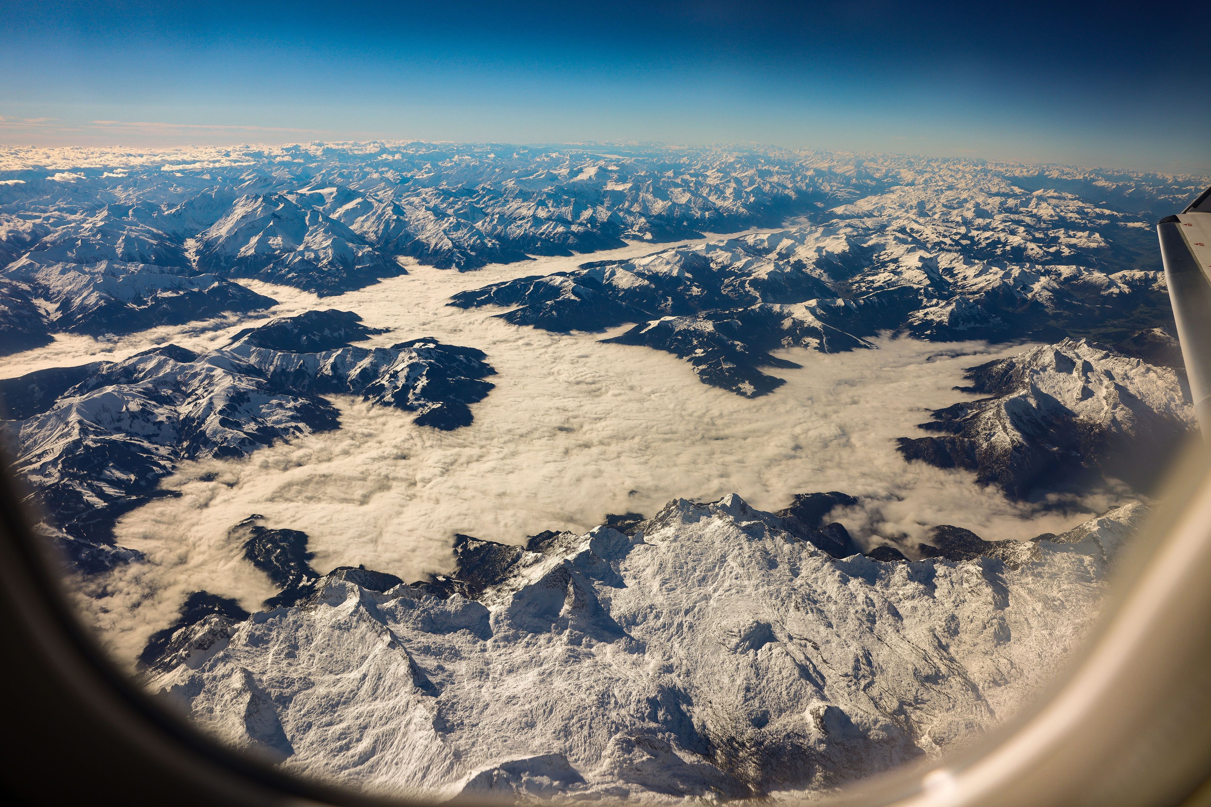 Blick auf verschneite Berggipfel aus einem Flugzeug heraus. (Symbolbild)