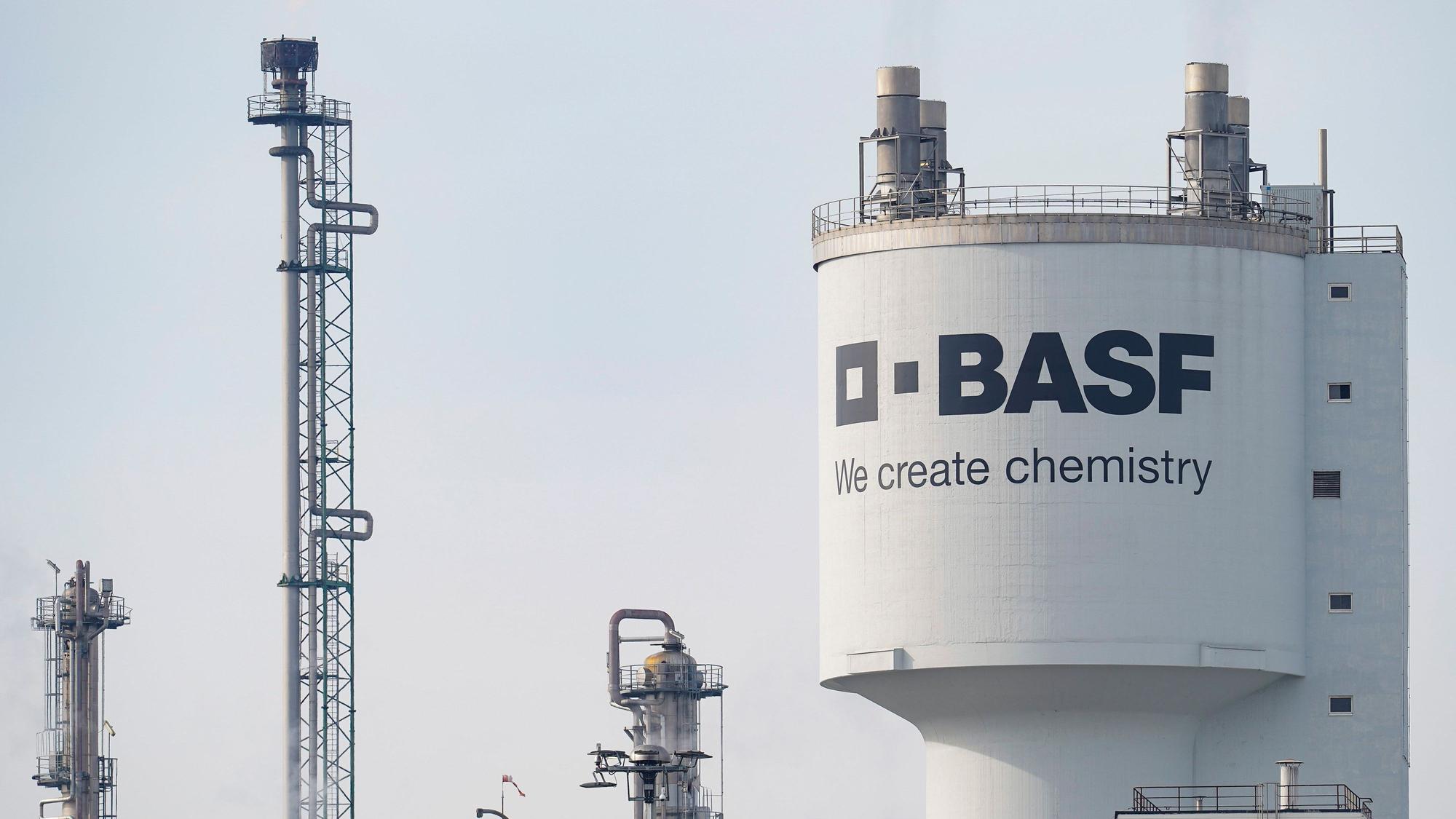 Ludwigshafen: Ein Turm mit der Aufschrift „BASF“ steht neben Schornsteinen auf dem Werksgelände des Chemiekonzerns BASF. (Archivbild)