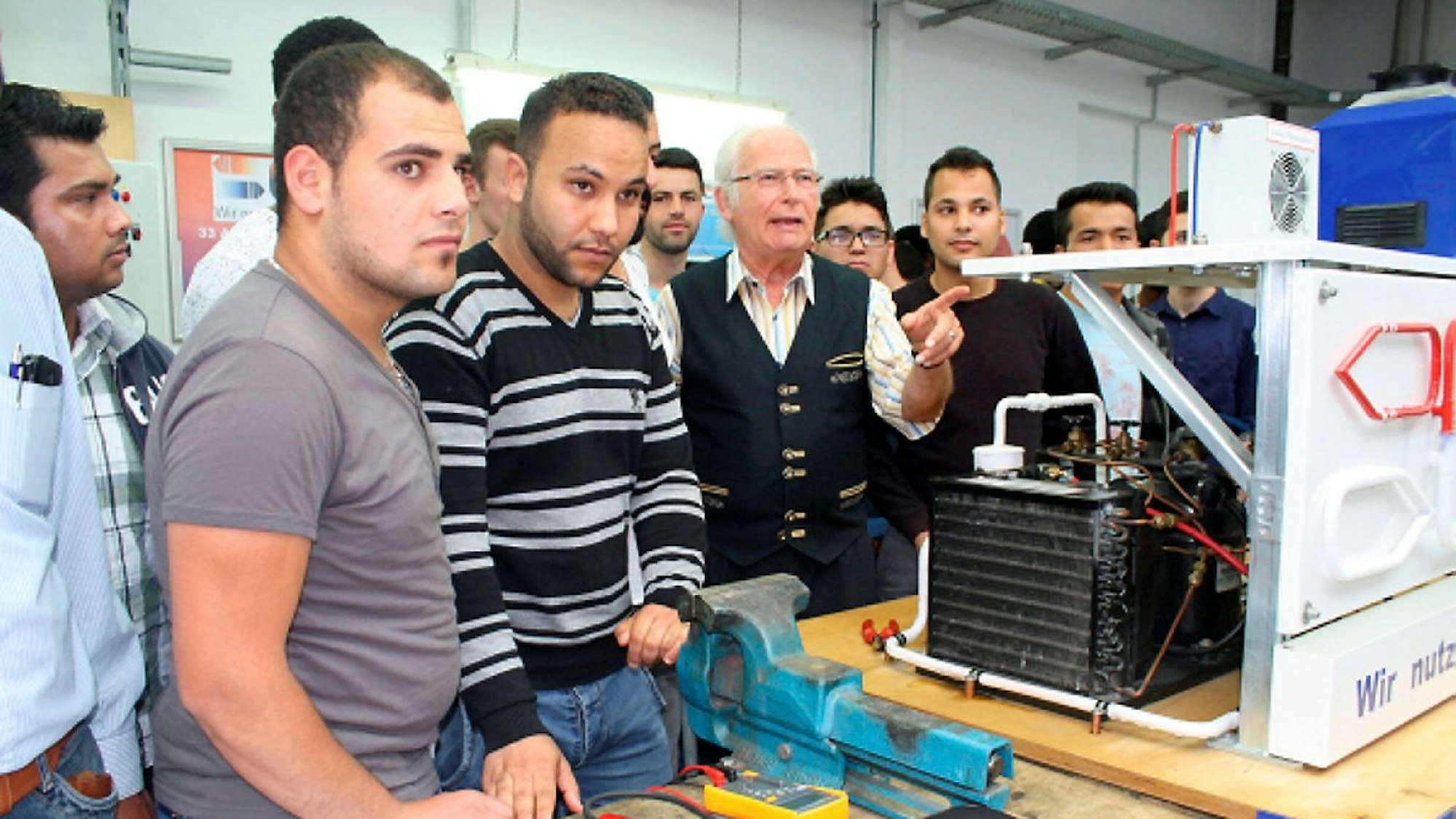 Oni-Chef Oehm führt Lindlarer Asylbewerber durch den Betrieb. Zehn von ihnen haben mittlerweile ihre Ausbildung absolviert. Archivbild