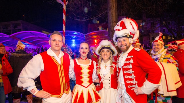 Zwei Tanzpaare grinsen in rot-weißen Kostümen in die Kamera.