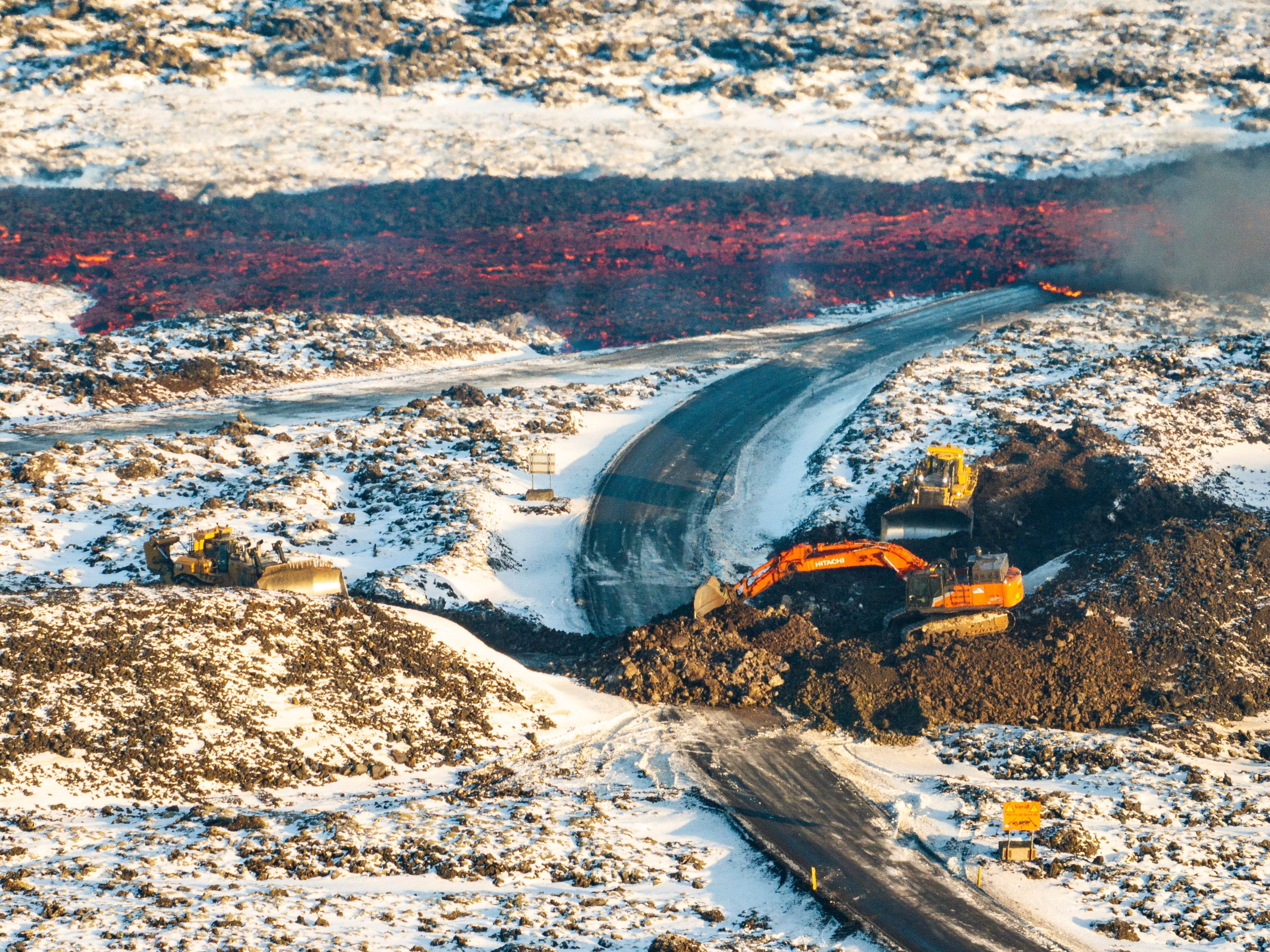 Lava fließt über die Hauptstraße nach Grindavik auf die Straße zur Blauen Lagune.