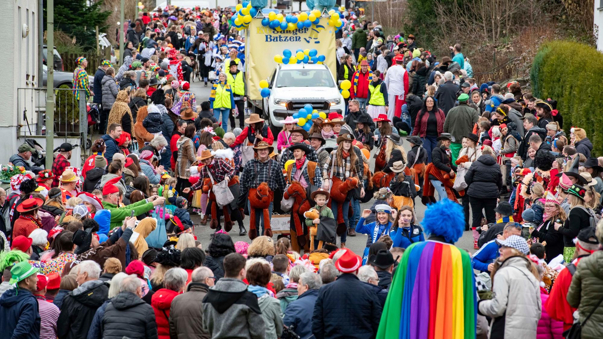 Eine Straße, voll mit Jecken. Ein Karnevalszug zieht durch den Ortskern in Hartegasse in Lindlar.