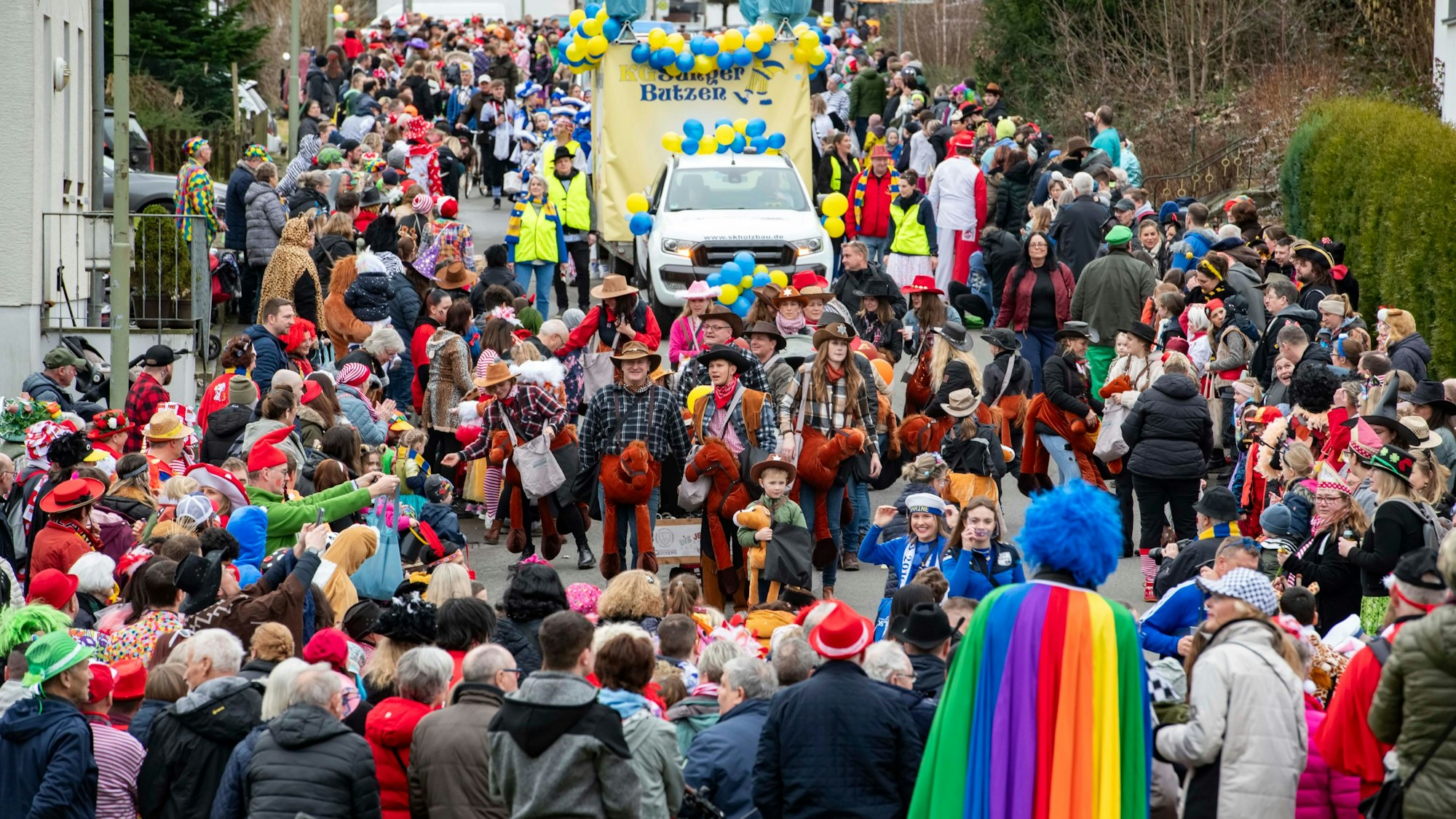 Eine Straße, voll mit Jecken. Ein Karnevalszug zieht durch den Ortskern in Hartegasse in Lindlar.