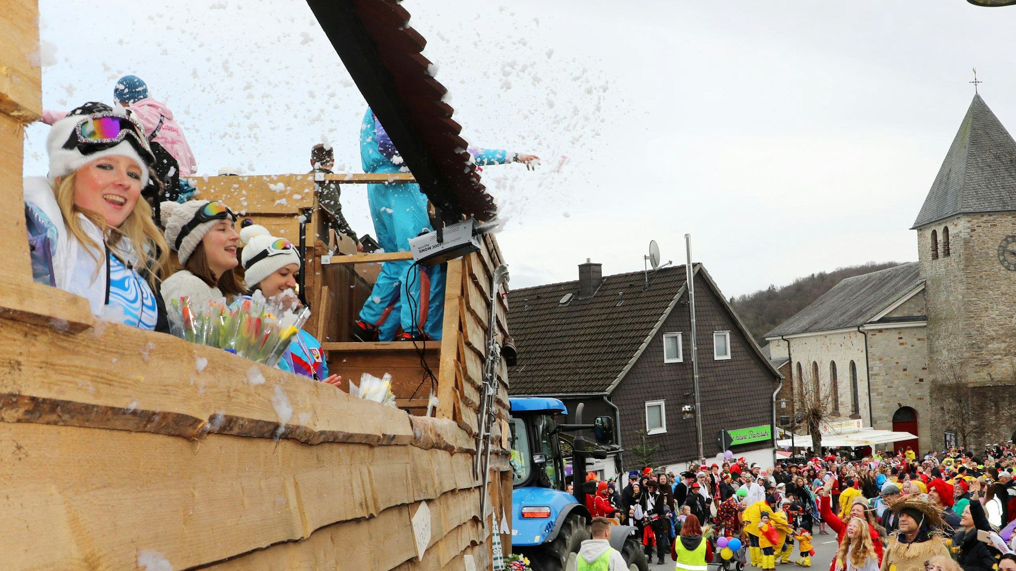 Von einem Karnevalswagen wird zerstäubter Schaum in die Luft gepustet.