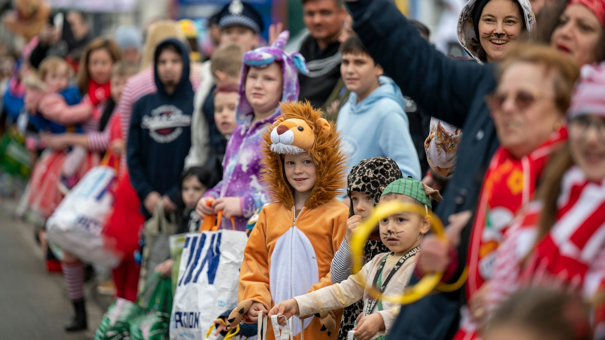 Kinder warten am Rande des Veedelszochs in Höhenberg auf Kamelle.