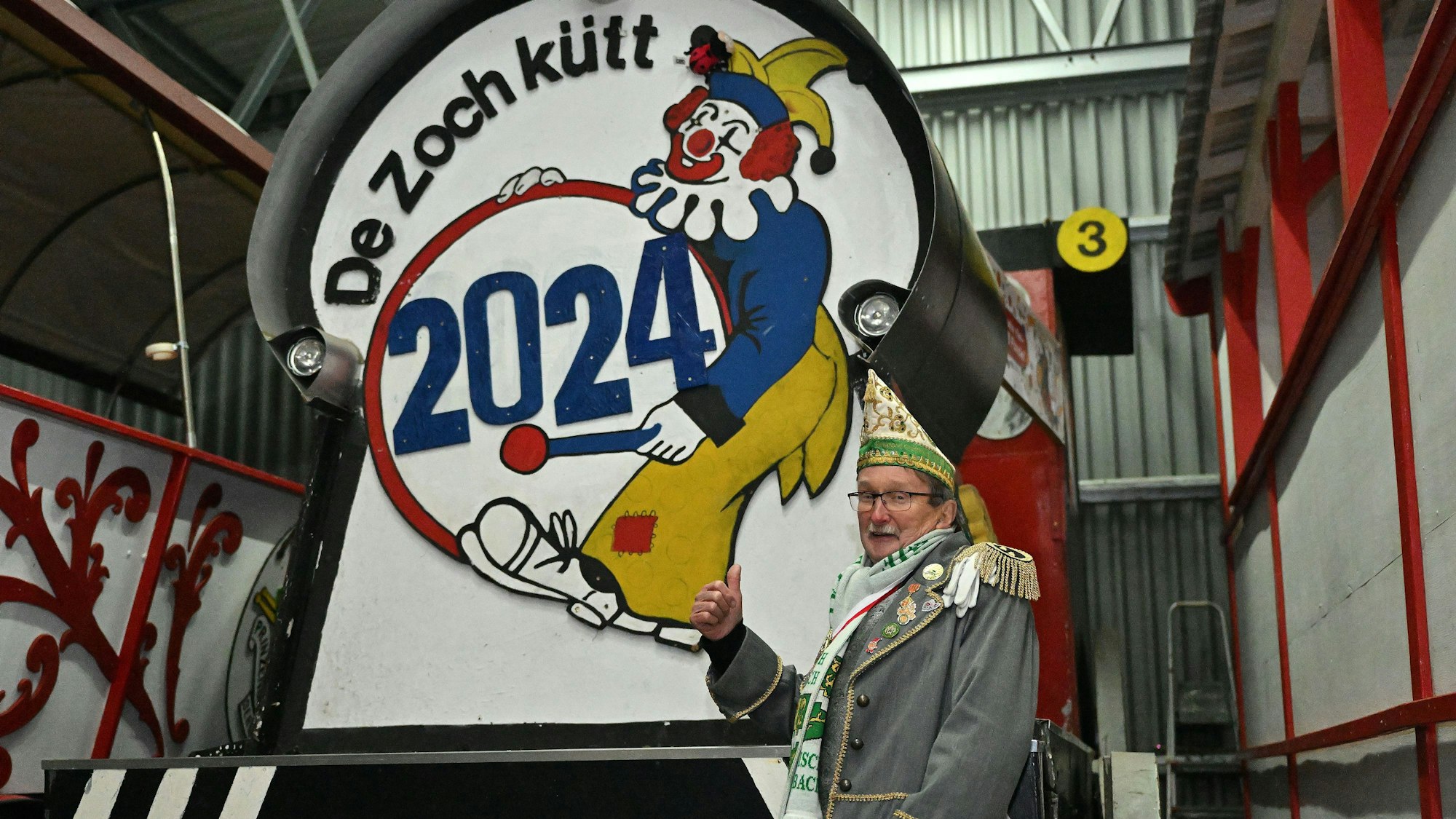 Zugleiter Helmut Kraus steht vor seiner Lokomotive in der Wagenbauhalle.