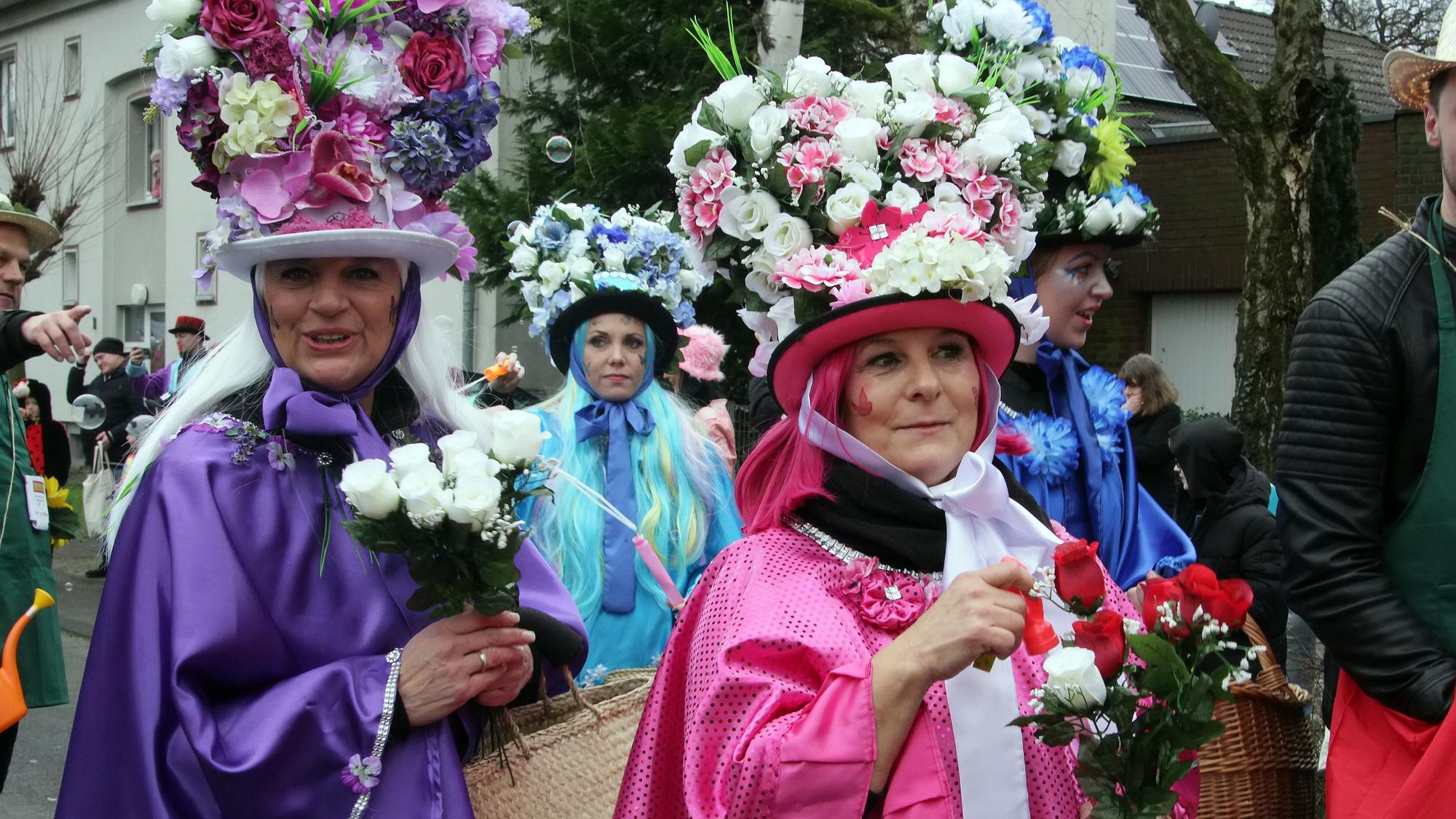 Närrinnen mit Blumensträußen auf dem Kopf.