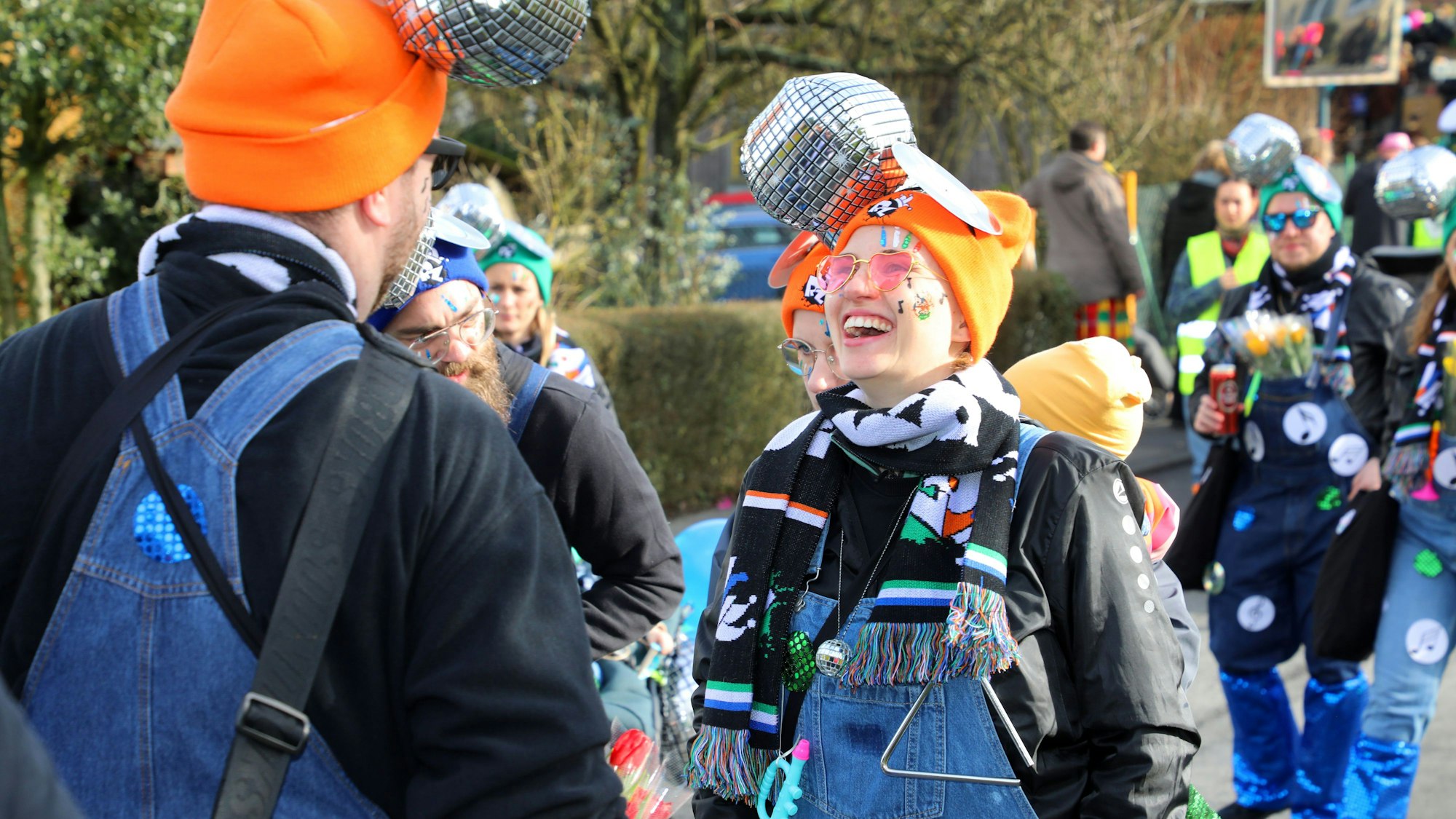 Jecke mit Diskokugeln auf dem Kopf lachen und laufen.