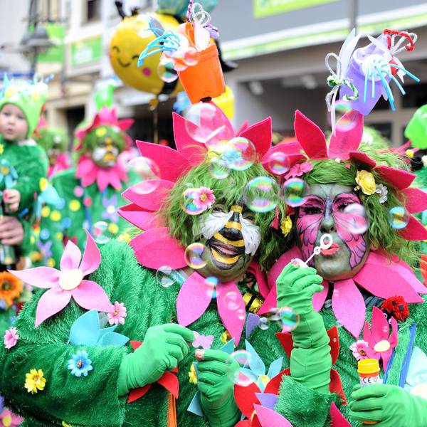 Als Blumenwiese verkleidete Menschen machen Seifenblasen.