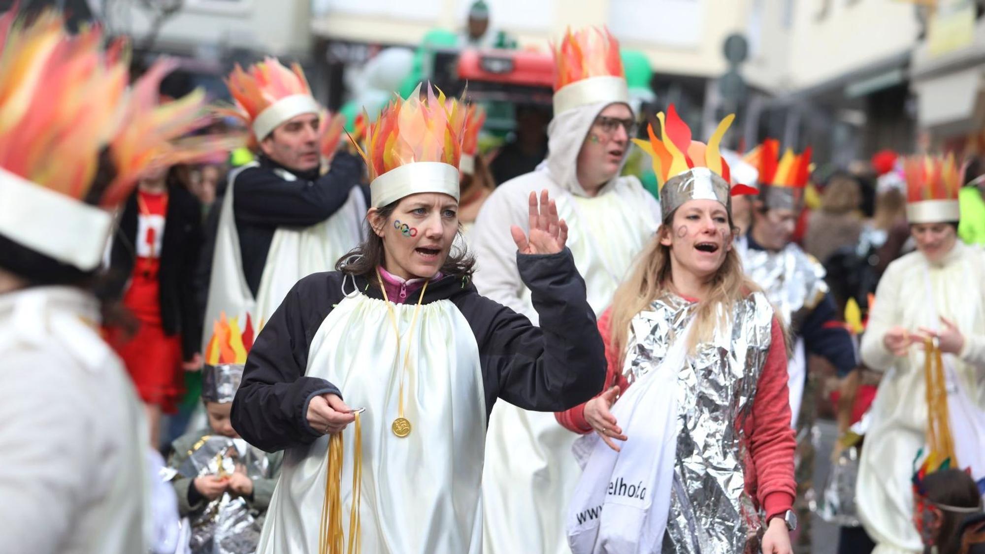 Zugteilnehmer mit „Flammenmützen“ ziehen durch die Straßen.