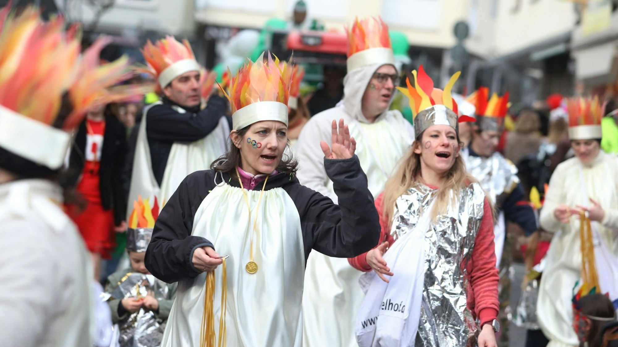 Zugteilnehmer mit „Flammenmützen“ ziehen durch die Straßen.