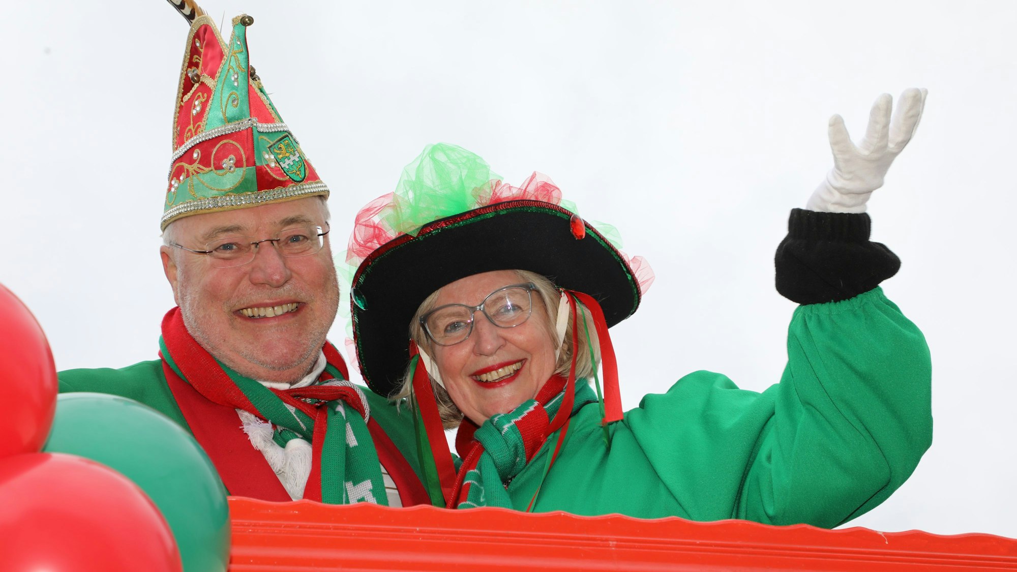 Ein Paar steht auf einem Wagen und lächelt.