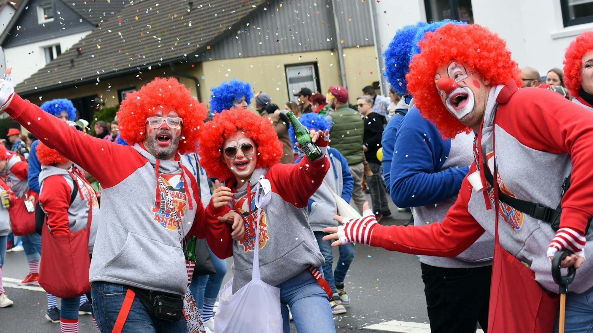 Mehrere Leute sind als Clowns verkleidet und schießen Konfetti in die Luft.