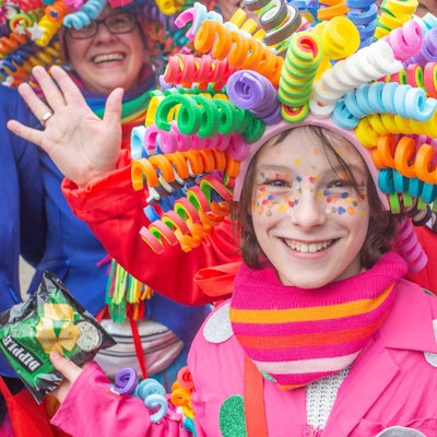 Ein Mädchen trägt eine bunte Perücke auf dem Kopf.
