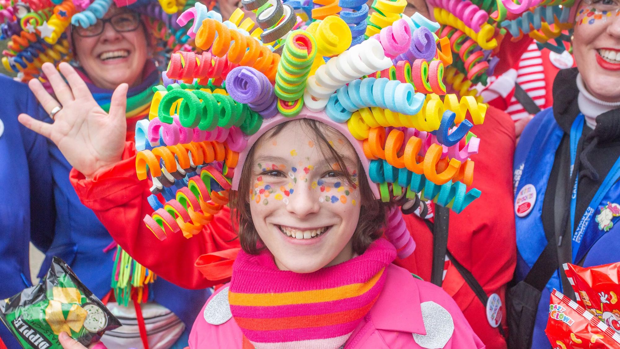Ein Mädchen trägt eine bunte Perücke auf dem Kopf.