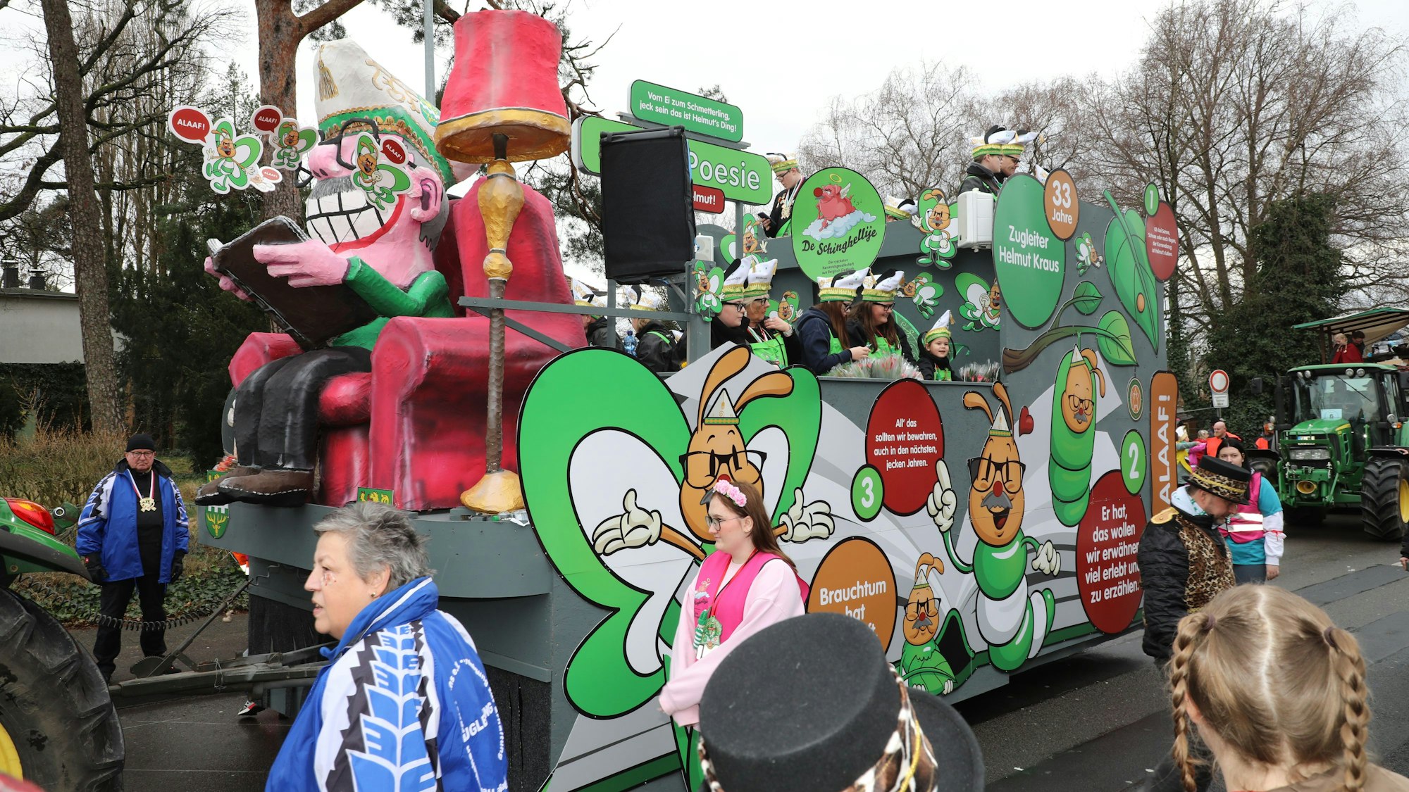 Ein Wagen zeigt einen Mann mit Narrenkappe in einem Sessel.
