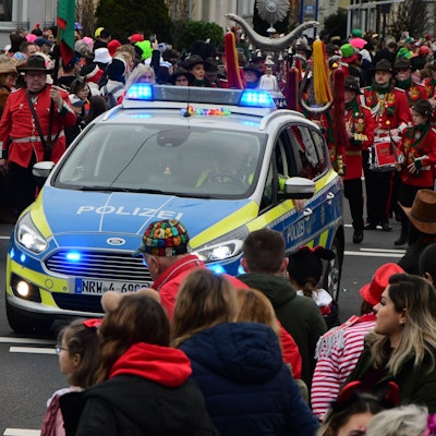 Ein Polizeiauto rollt an der Spitze des Südstadtzugs in Euskirchen, Zuschauer säumen die Straßenränder.
