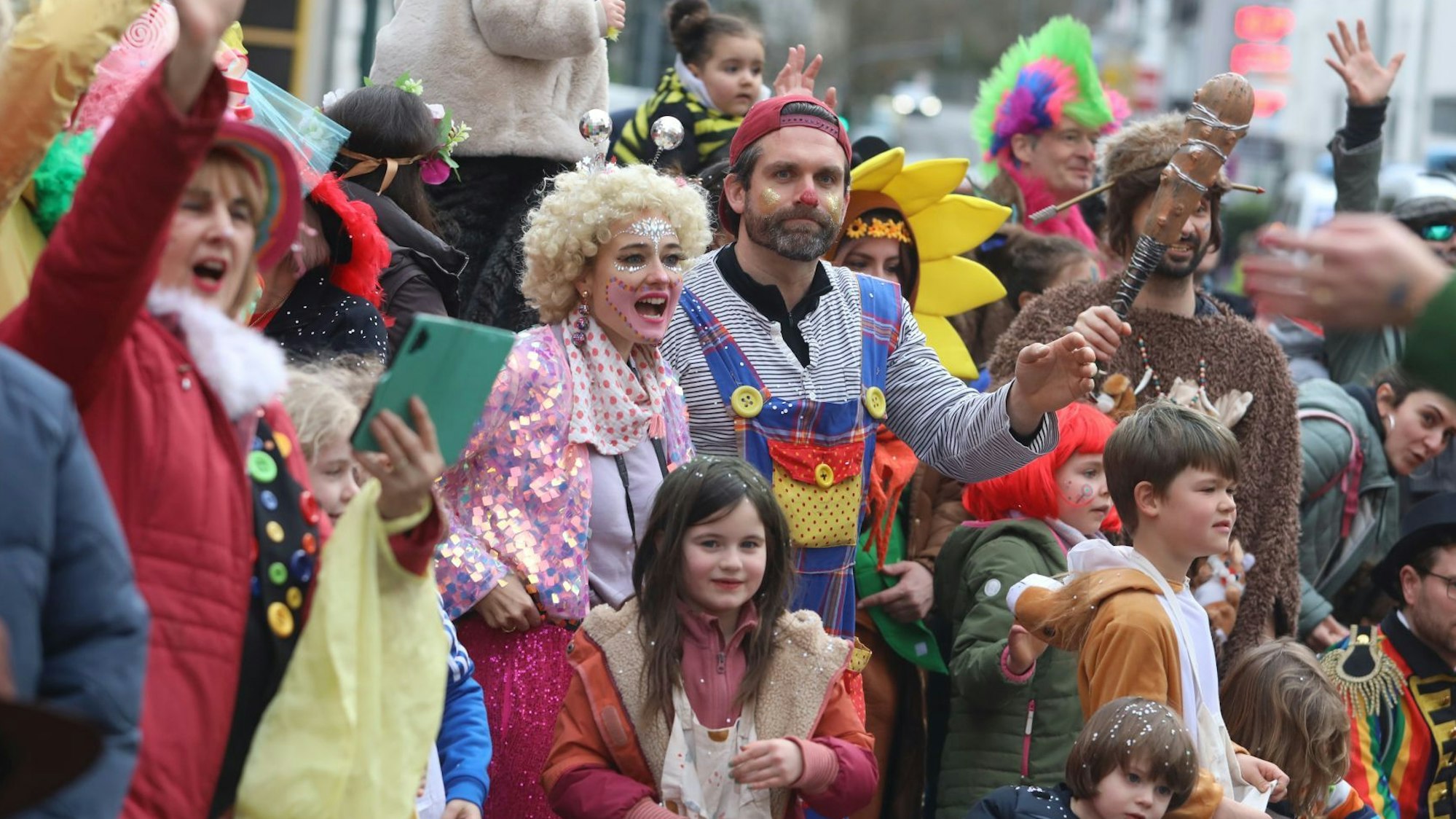 Kinder und Erwachsene stehen bunt kostümiert am Zugweg.