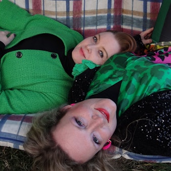 Zwei Frauen liegen auf einer Bank.