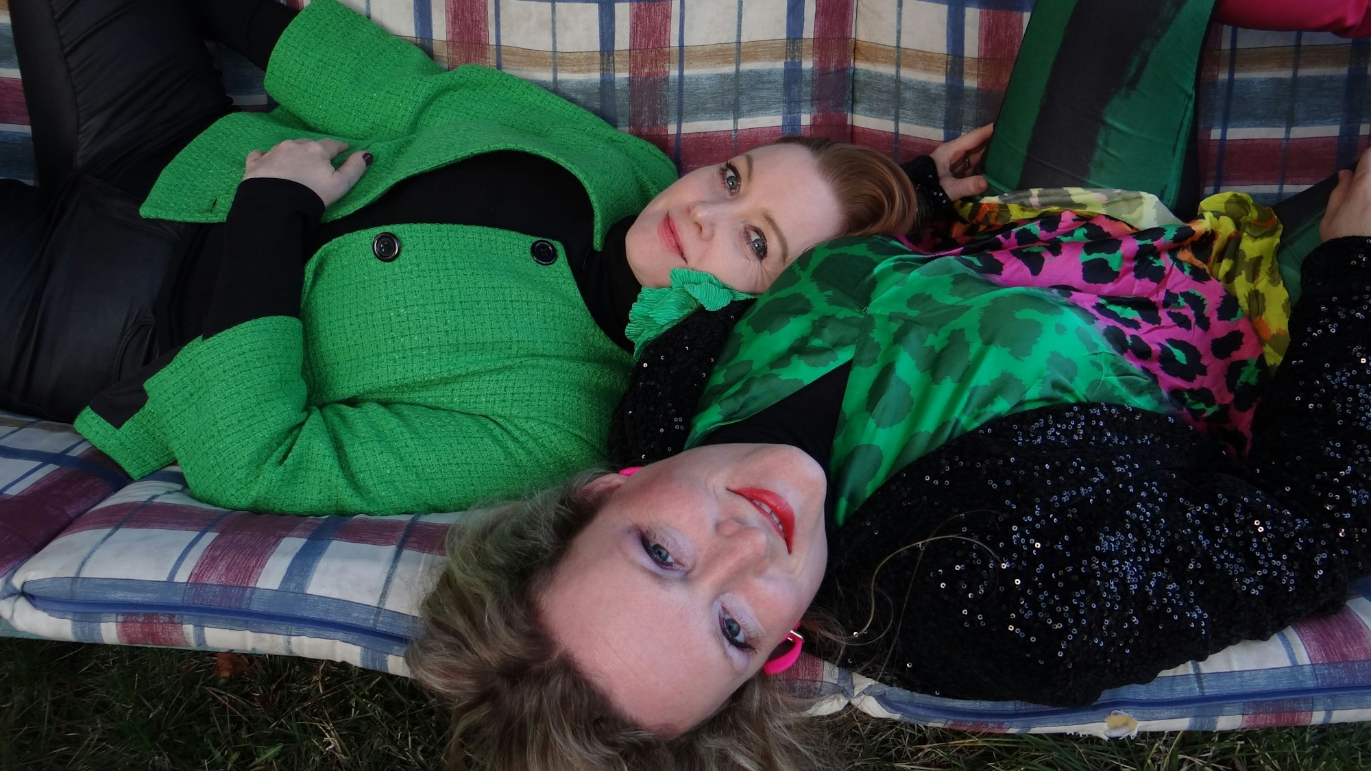 Zwei Frauen liegen auf einer Bank.