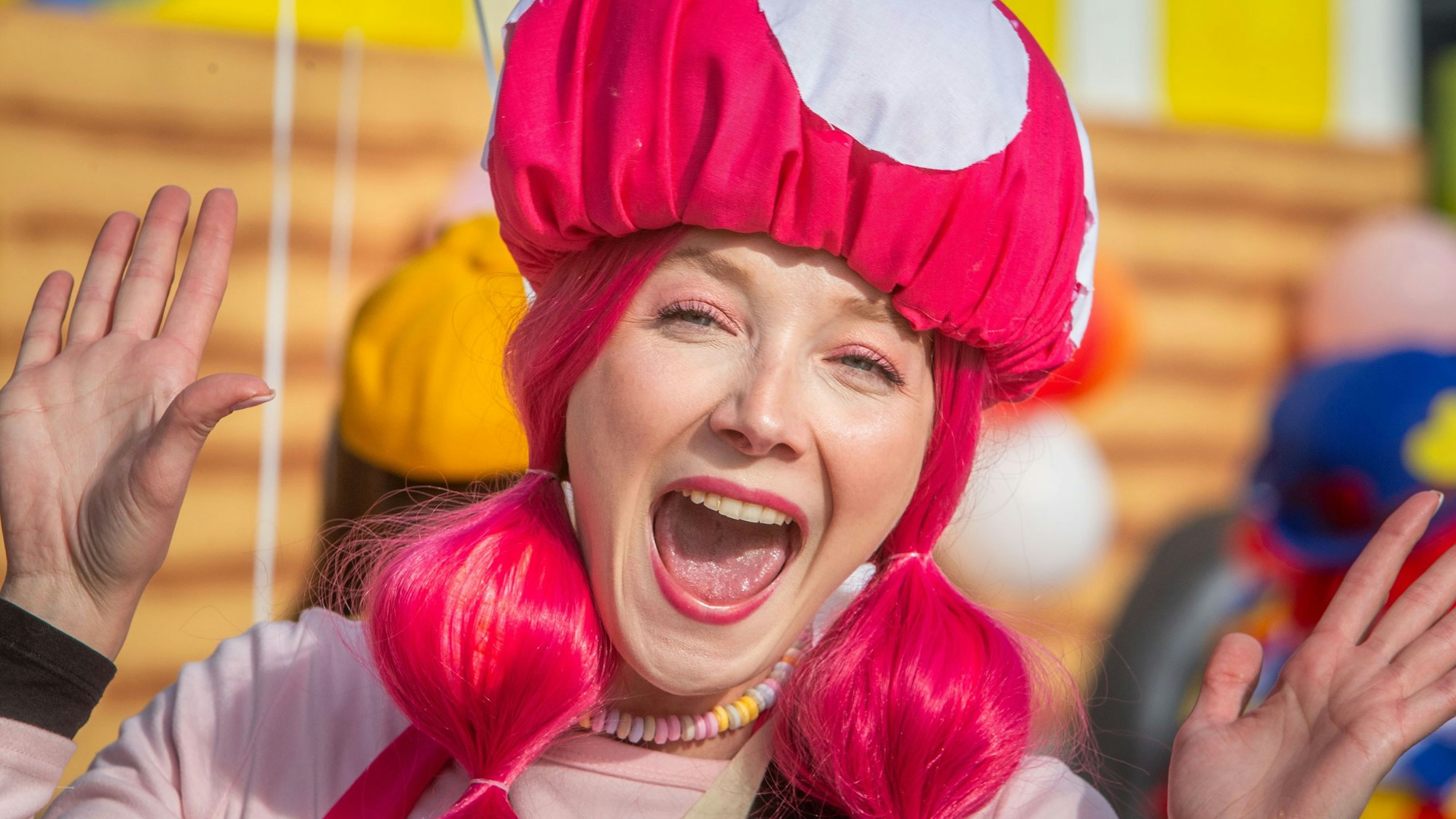 Blick auf eine kostümierte Frau, die herzlich lacht.