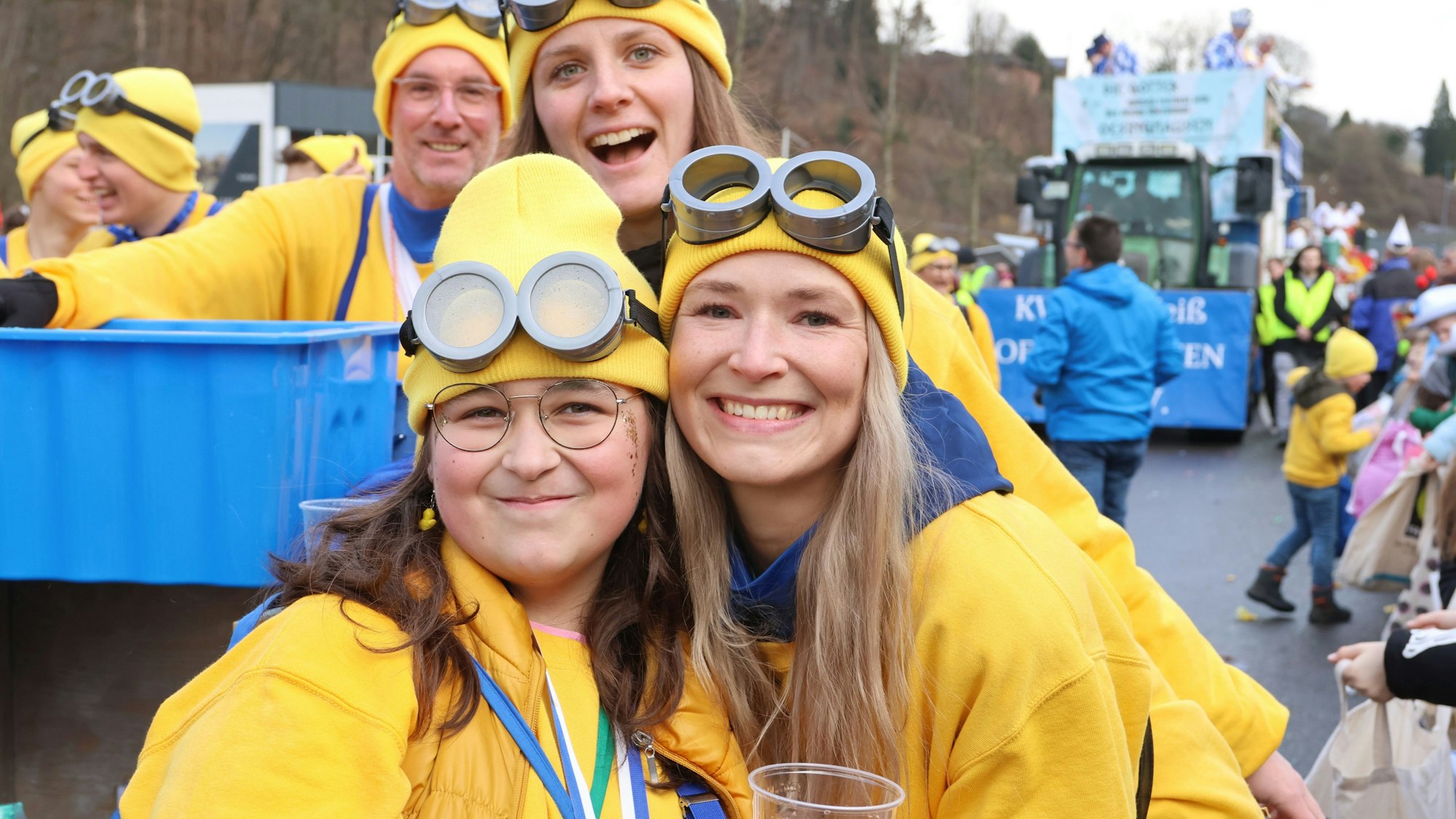 Zwei junge Frauen mit dicken Brillen und gelben Mützen.