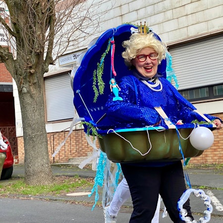 Zu sehen ist eine als Muschel verkleidete Frau.