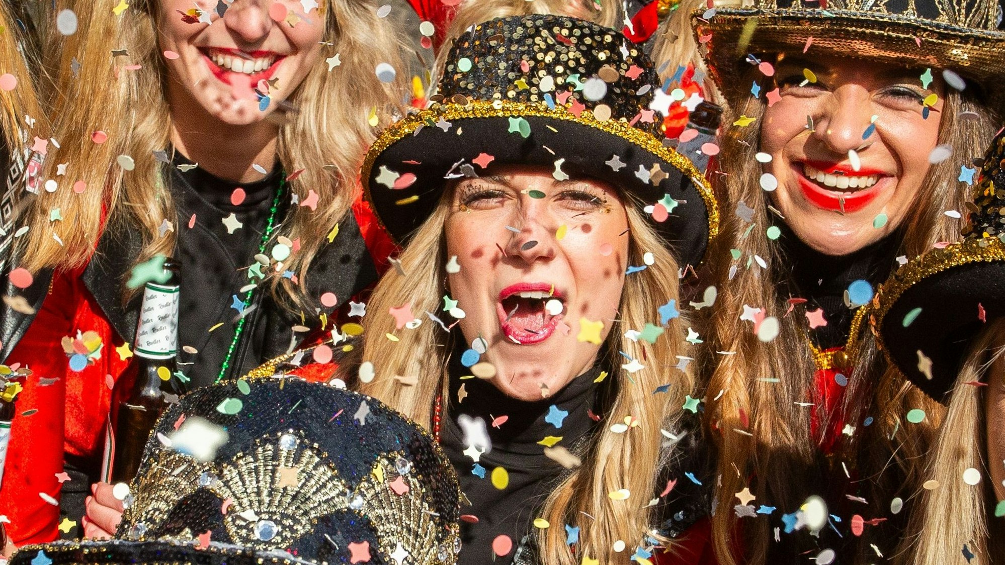 Mehrere kostümierte Damen im Konfettiregen.