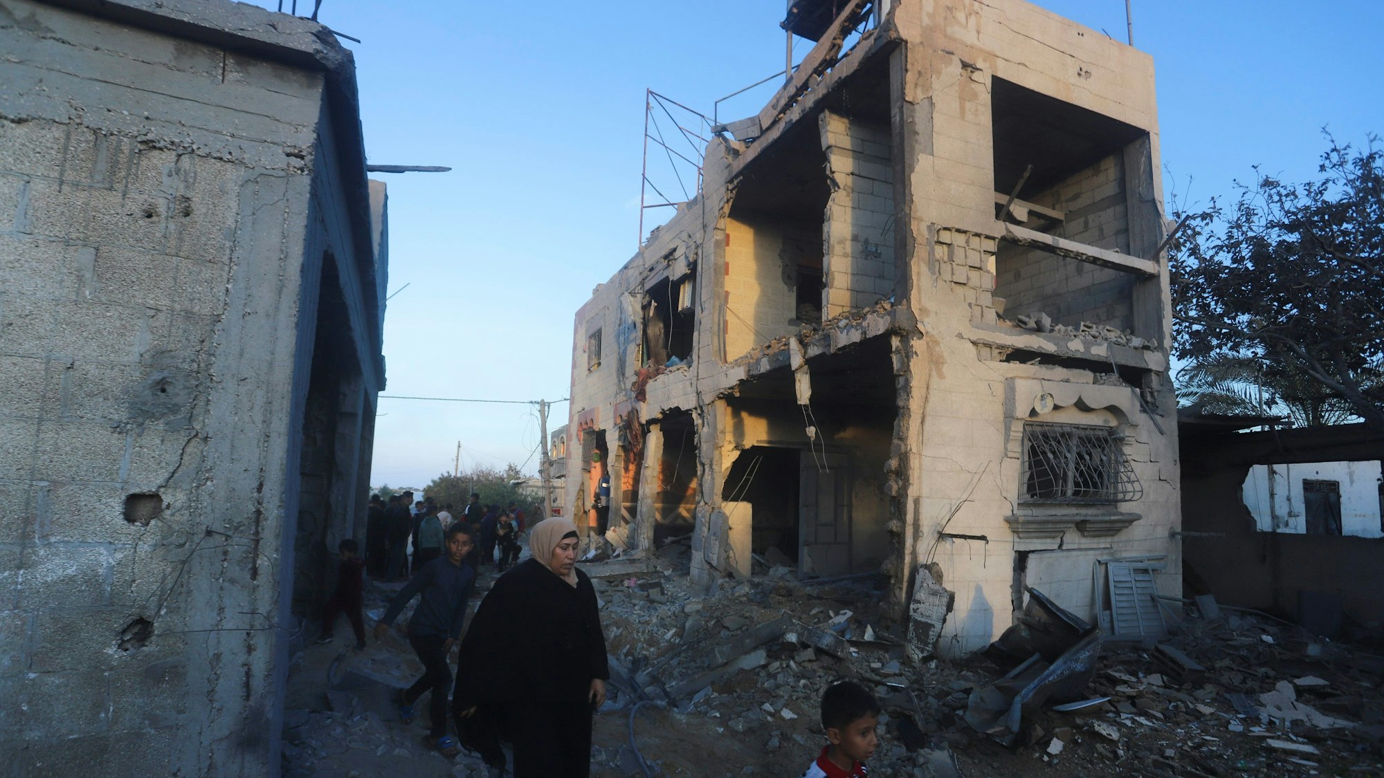Palästinenser gehen an einem Wohnhaus vorbei, das bei einem israelischen Luftangriff zerstört wurde.