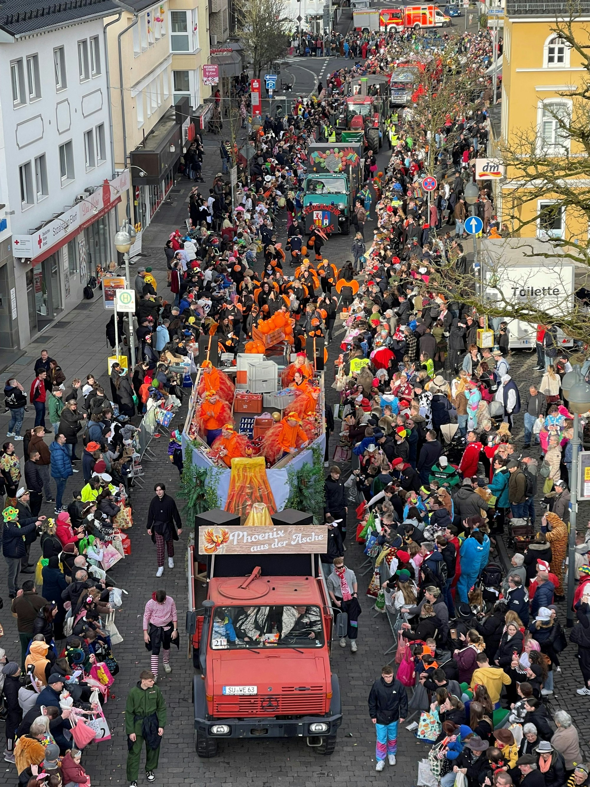 Ein Aufsichtsfoto des Eitorfer Rosenmontagszugs mit dem Wagen von Weco, der an hunderten Zuschauern vorbeifährt.
