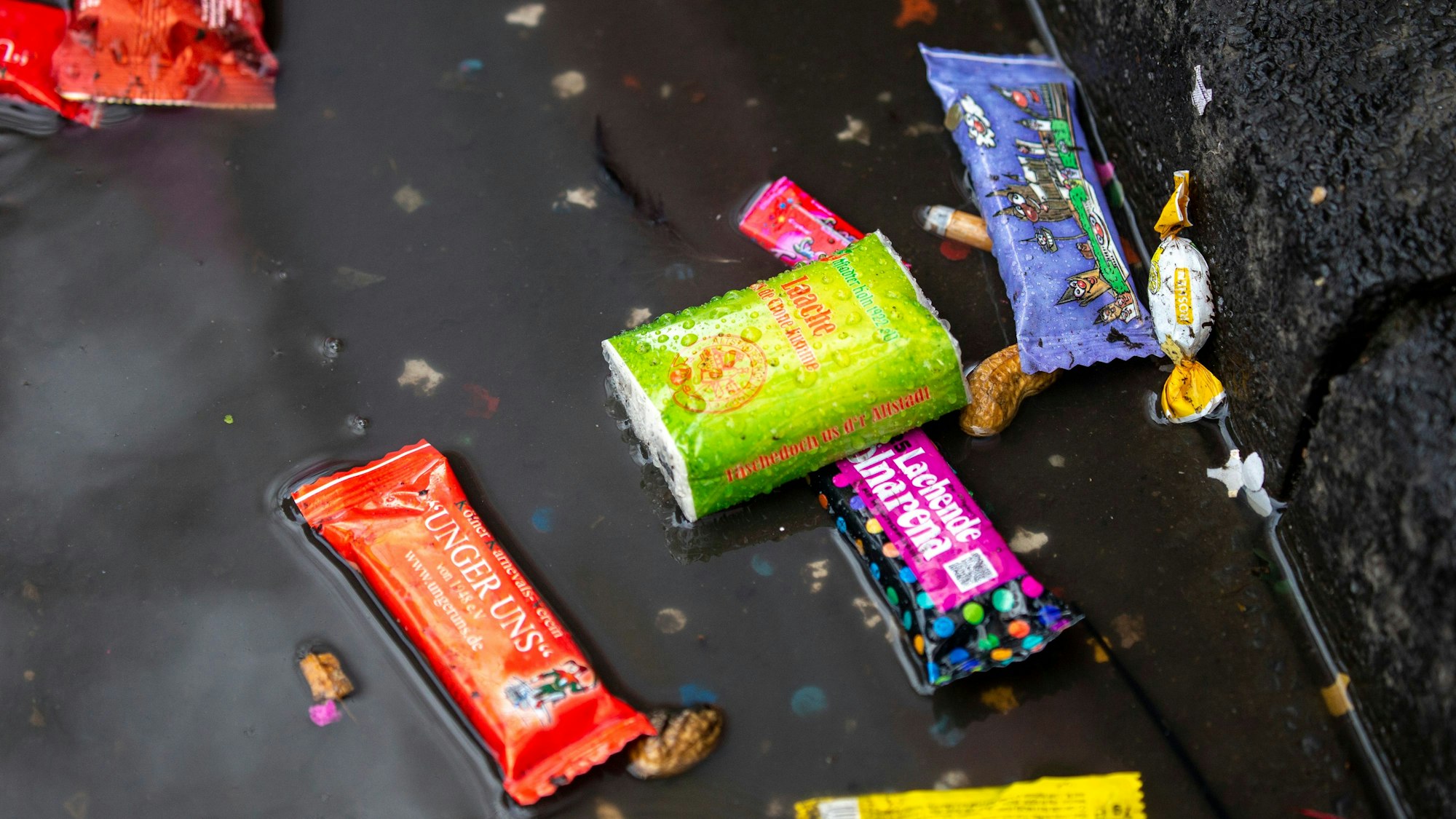 Viel Wurfmaterial bleibt beim Rosenmontagszug auf der Straße liegen.