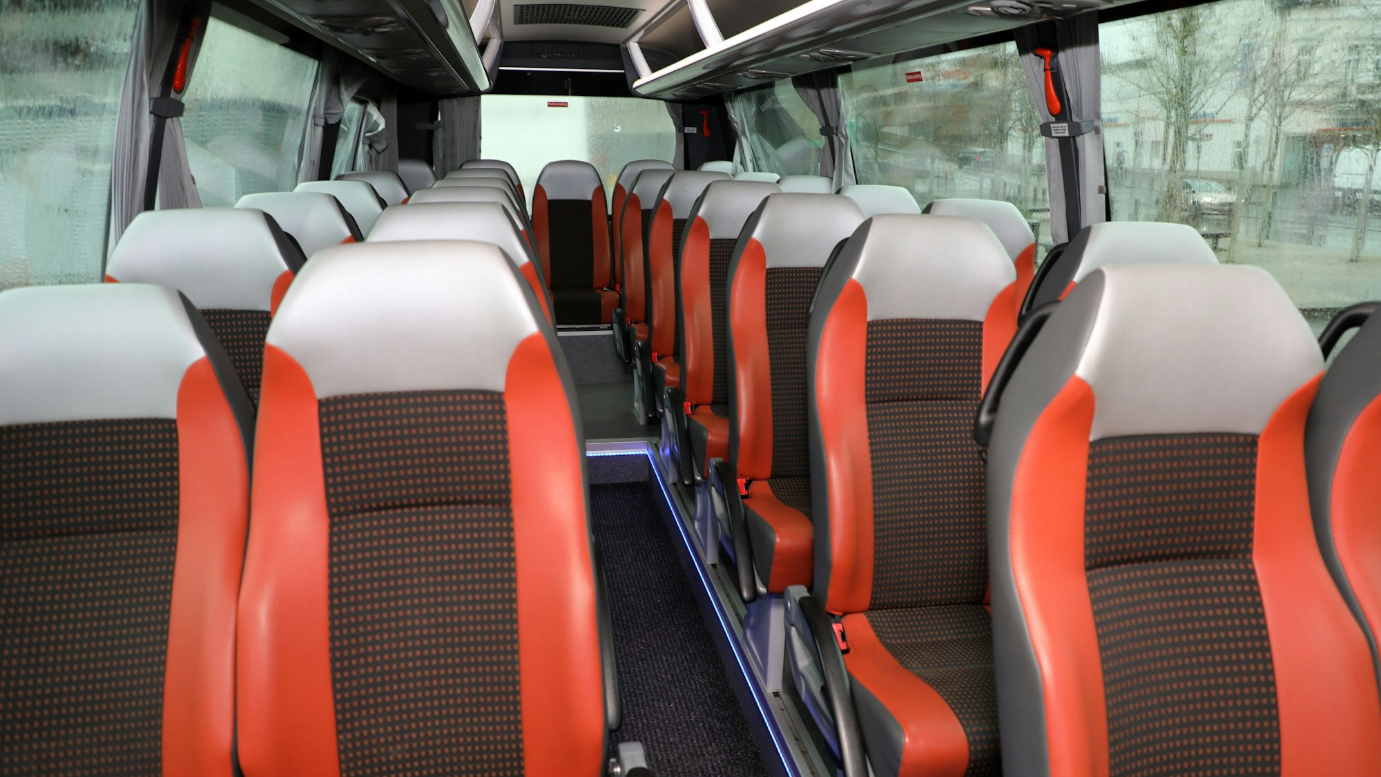 Innenansicht des Bergischen Wanderbusses: Bequeme Sitze mit Sicherheitsgurten, große Fenster.