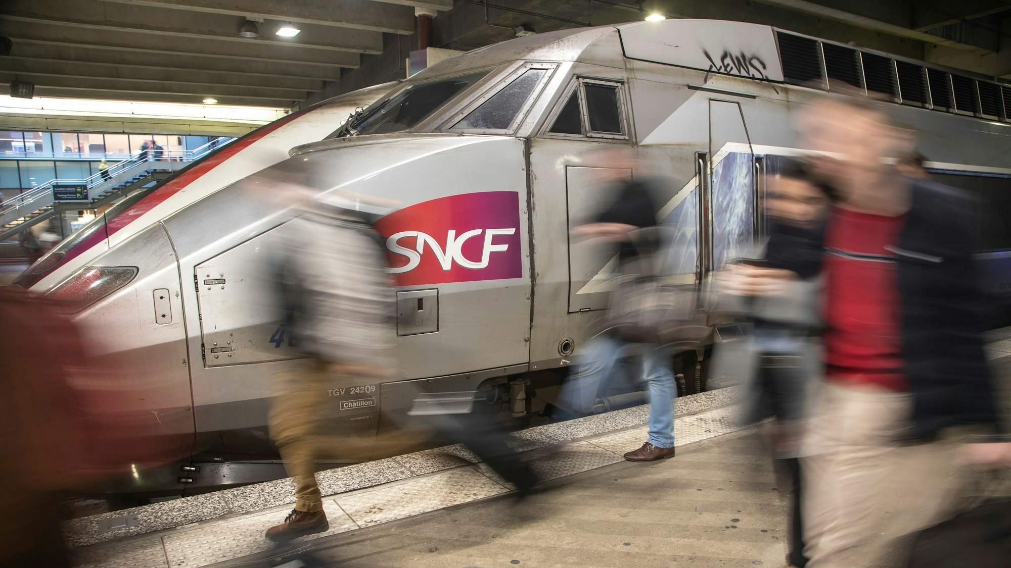 Reisende kommen mit einem SNCF Zug am Bahnhof Montparnasse an.