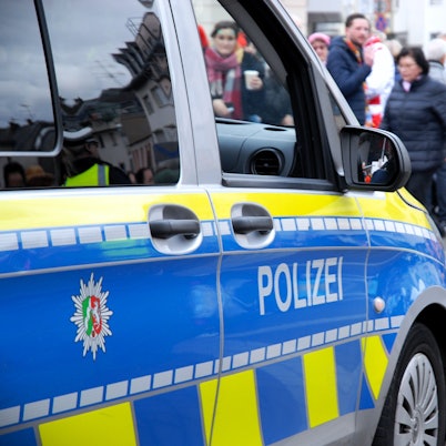 Das Bild zeigt einen Streifenwagen am Karnevalszug.