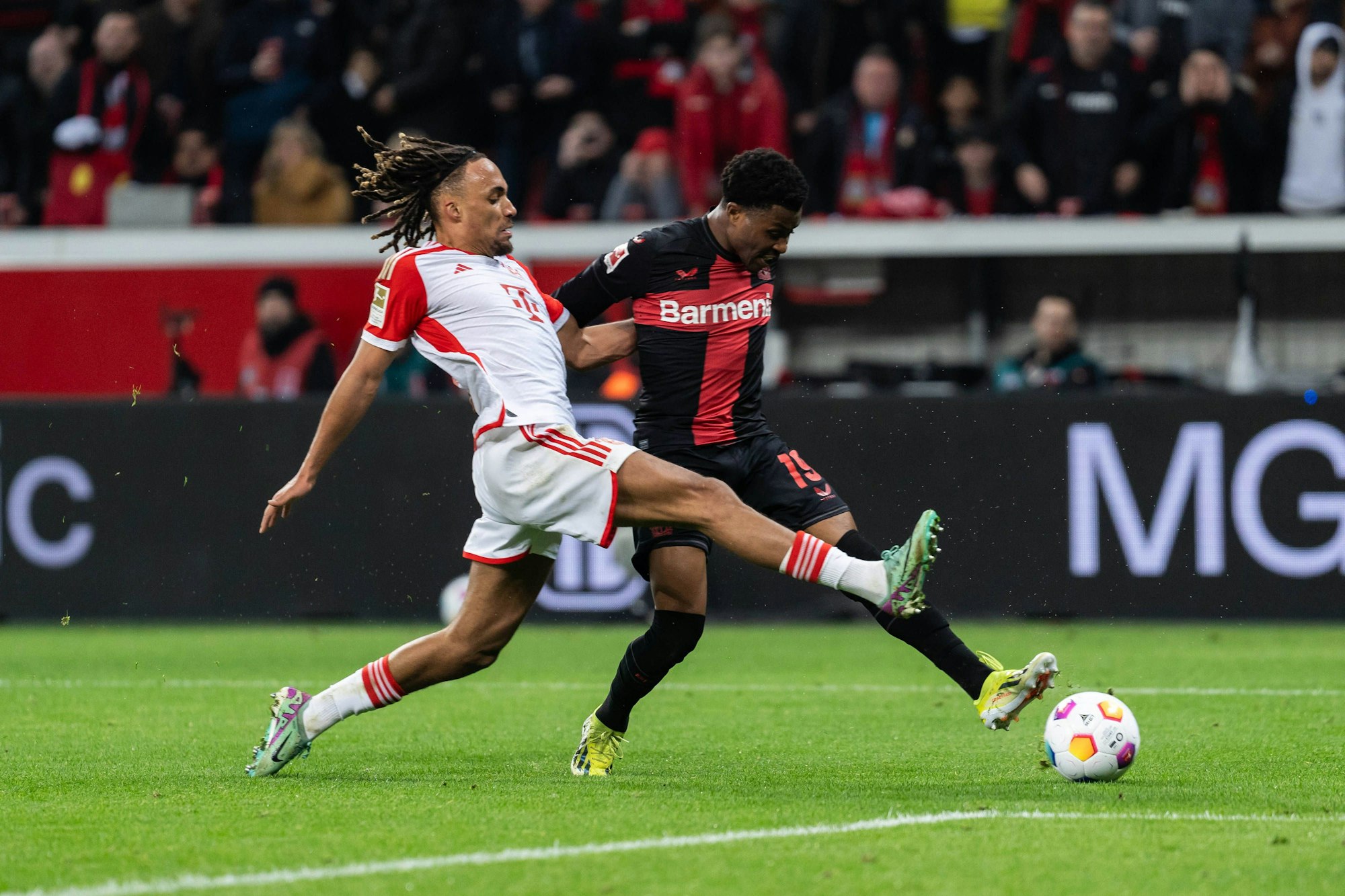 Half fleißig mit, die Münchner um Sacha Boey gehörig durcheinanderzuwirbeln: Leverkusens Nathan Tella (rechts).