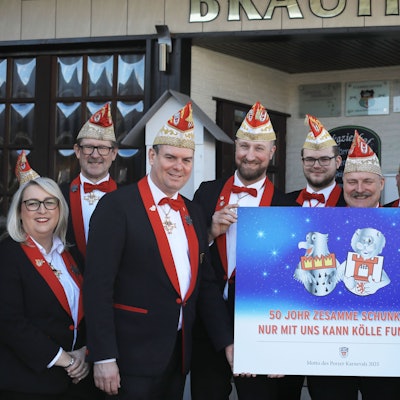 Neun Männer und eine Frau halten ein großes Schild mit dem neuen Sessionsmotto hoch.