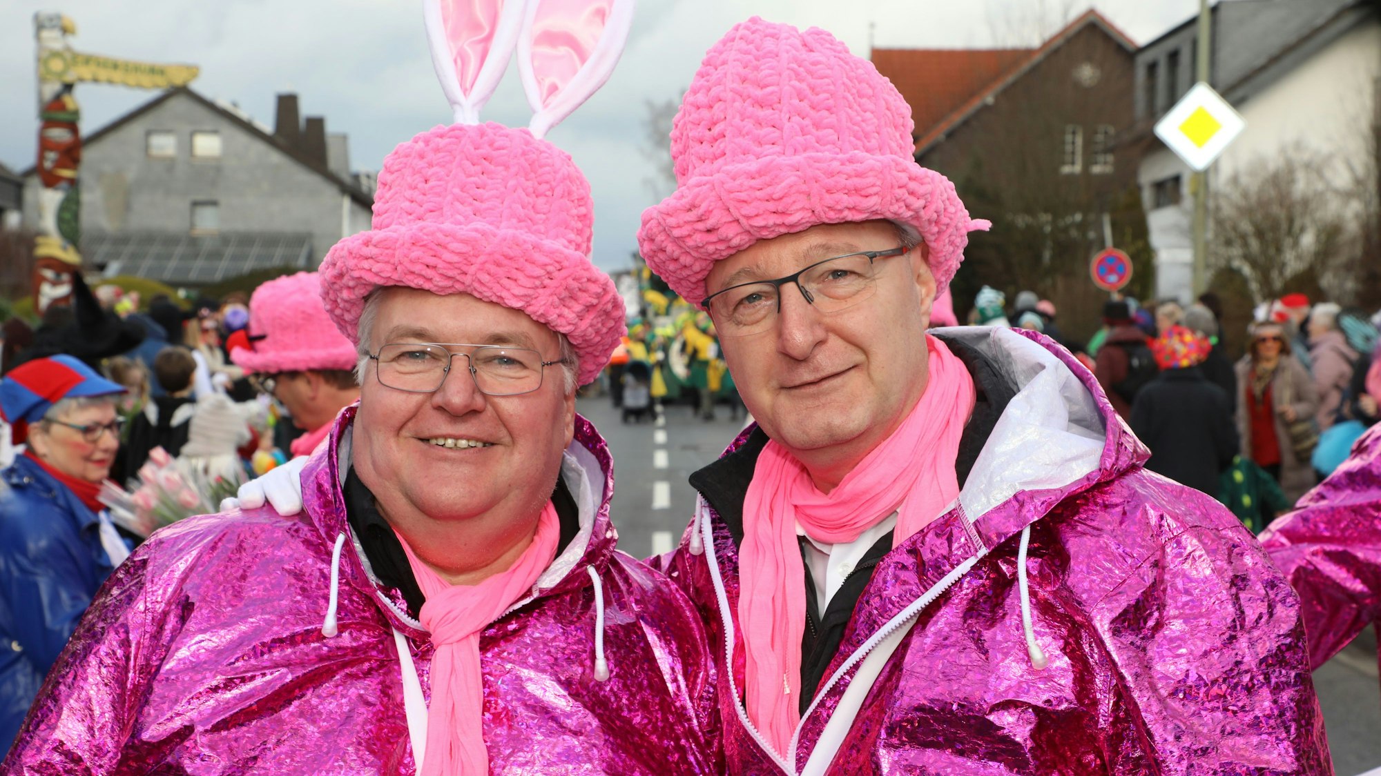 Zwei Männer in schrillen Kostümen stehen nebeneinander.