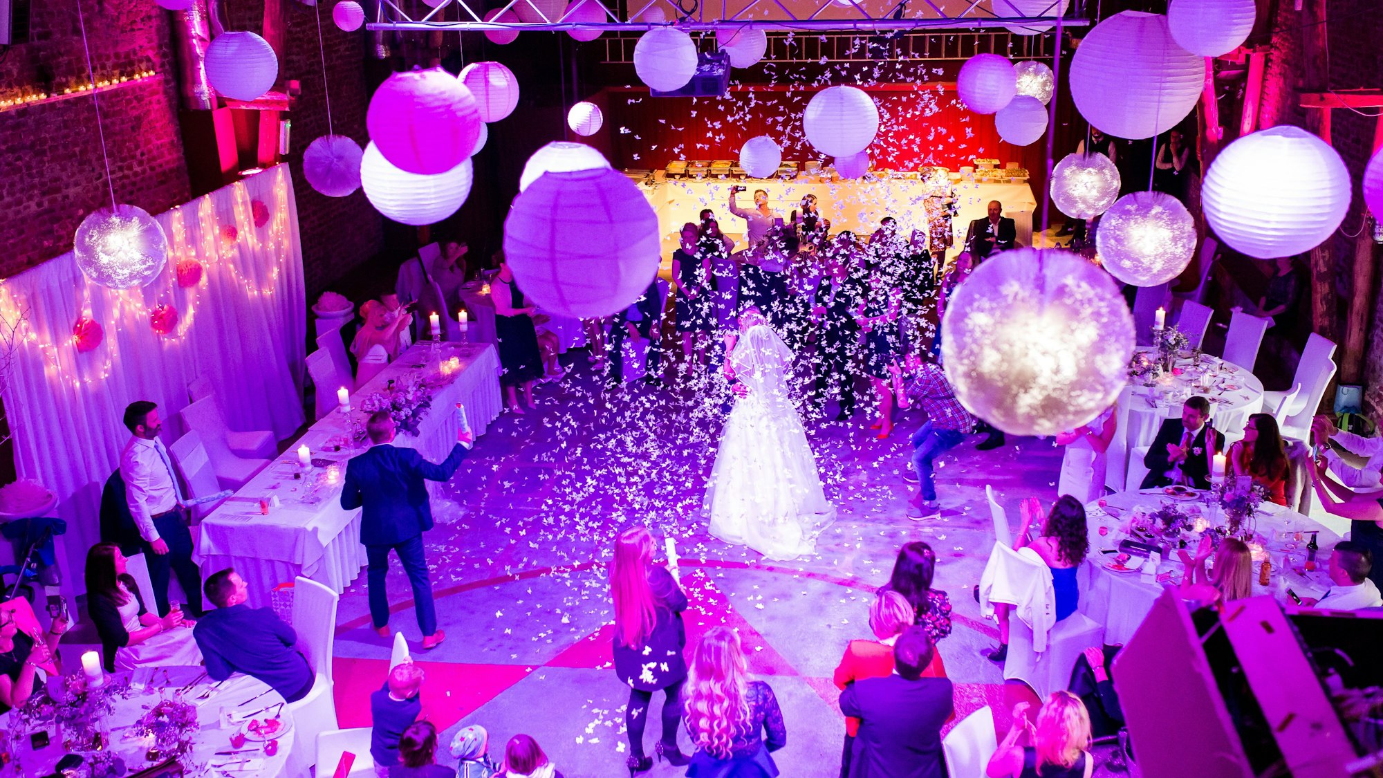 Es ist eine Scheune zu sehen, in der alles für eine Hochzeit hergerichtet ist.