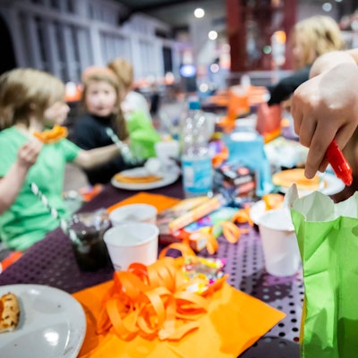 Ein Kind öffnet bei einem Kindergeburtstag im Jump House Berlin-Reinickendorf eine Geschenktüte.