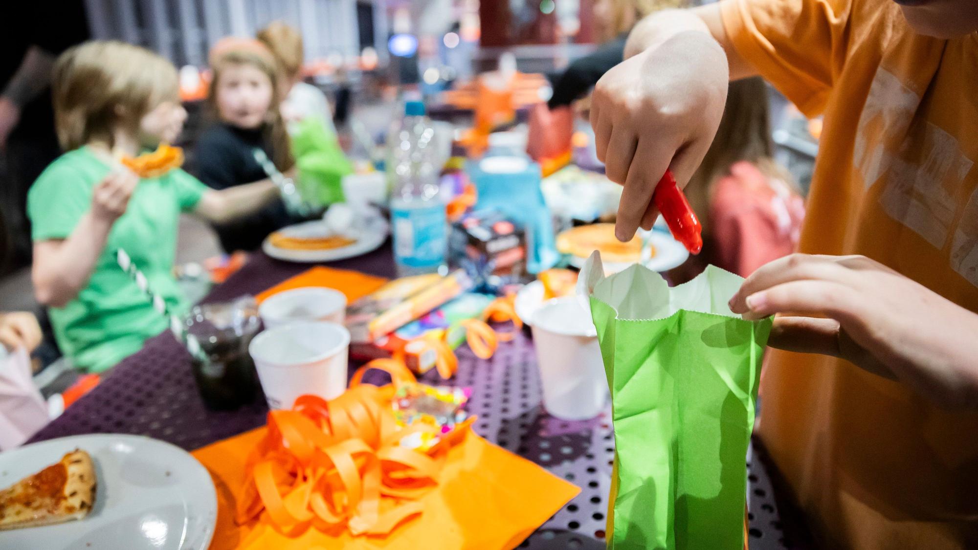 Ein Kind öffnet bei einem Kindergeburtstag im Jump House Berlin-Reinickendorf eine Geschenktüte.