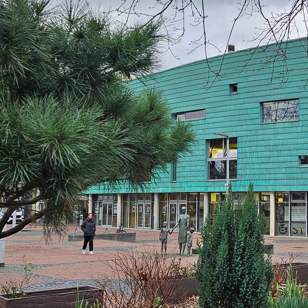 Ein großes Gebäude in der Form eines Schiffbugs mit grüner Fassade.