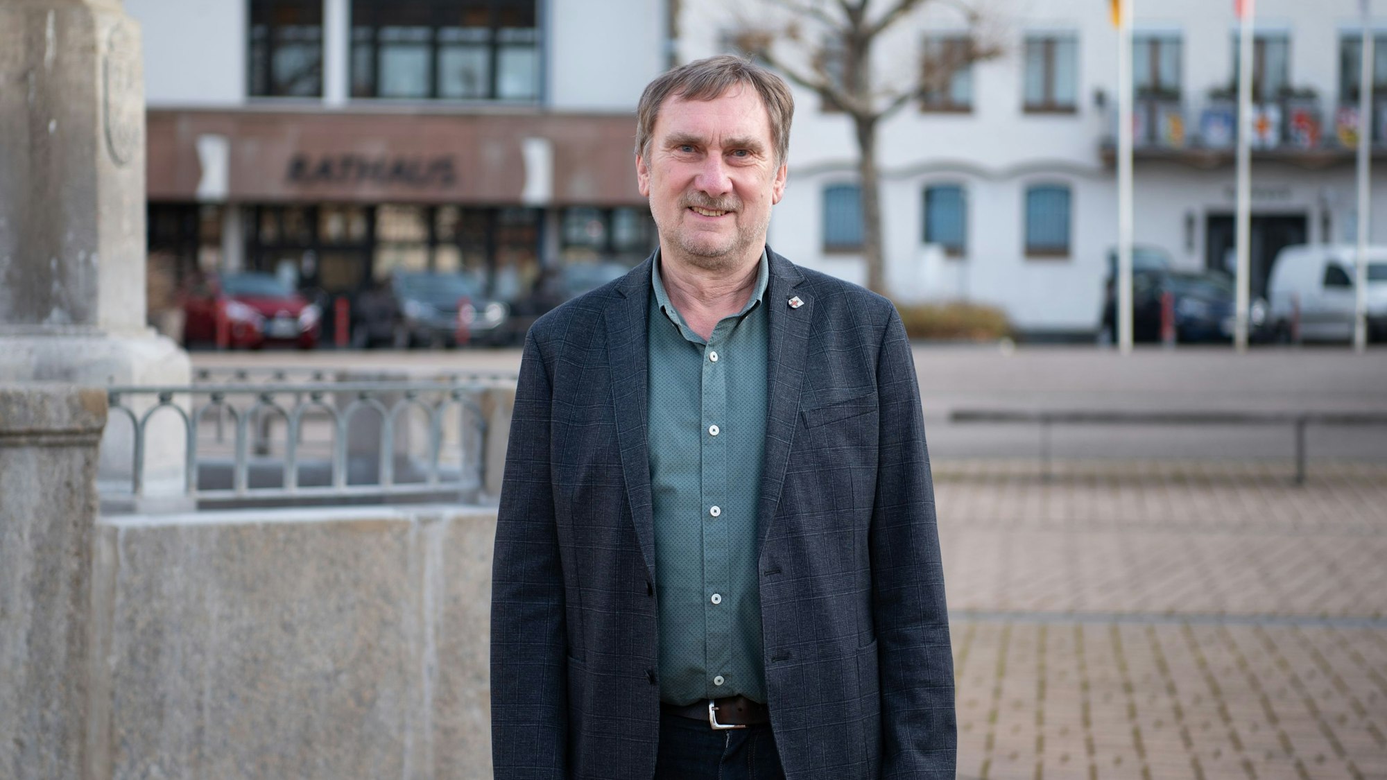 Ottmar Voigt, Kämmerer und Erster Beigeordneter der Stadt Zülpich, steht auf dem Marktplatz vor dem Rathaus.