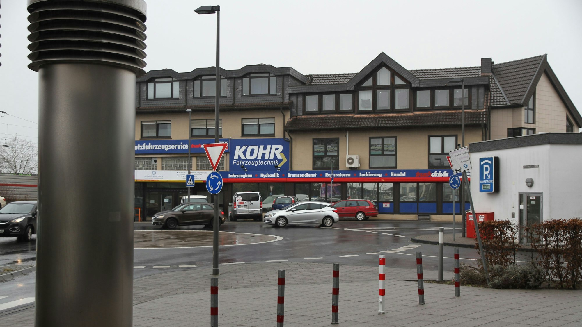 Ein Firmengebäude mit blauen Werbetafeln an einem Kreisverkehr