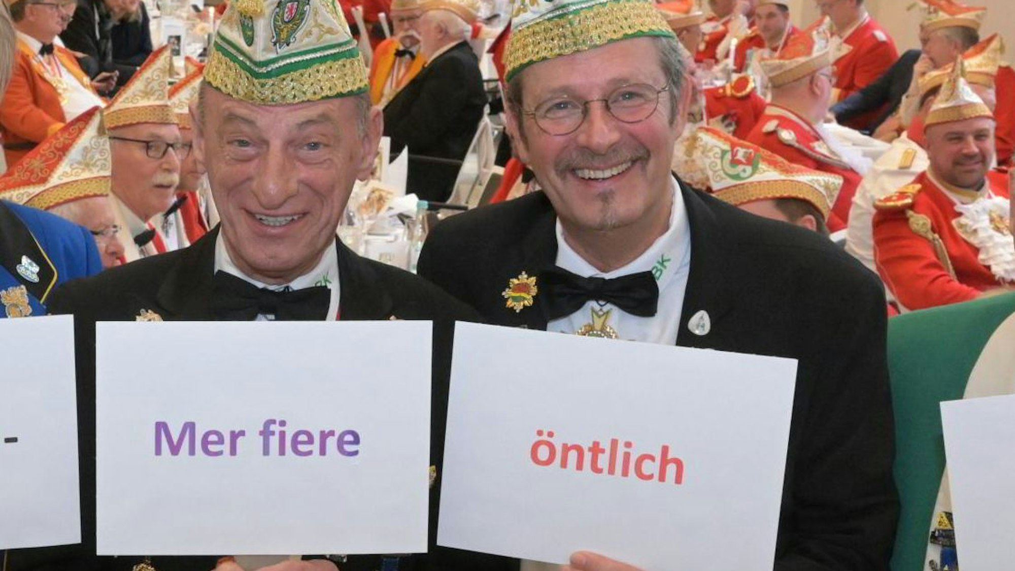 Zwei Männer halten Schilder mit Wörtern in die Höhe.