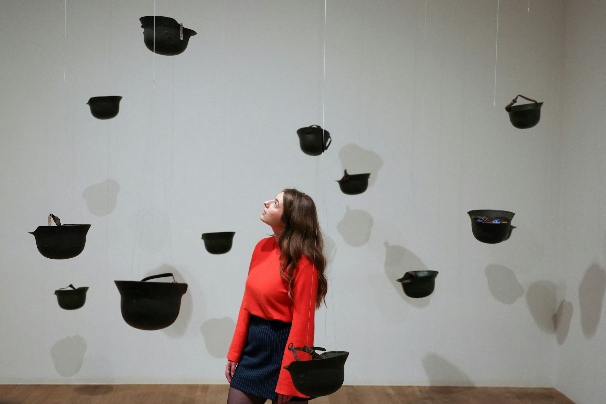 Eine Besucherin betrachtet das Werk „Helmets“