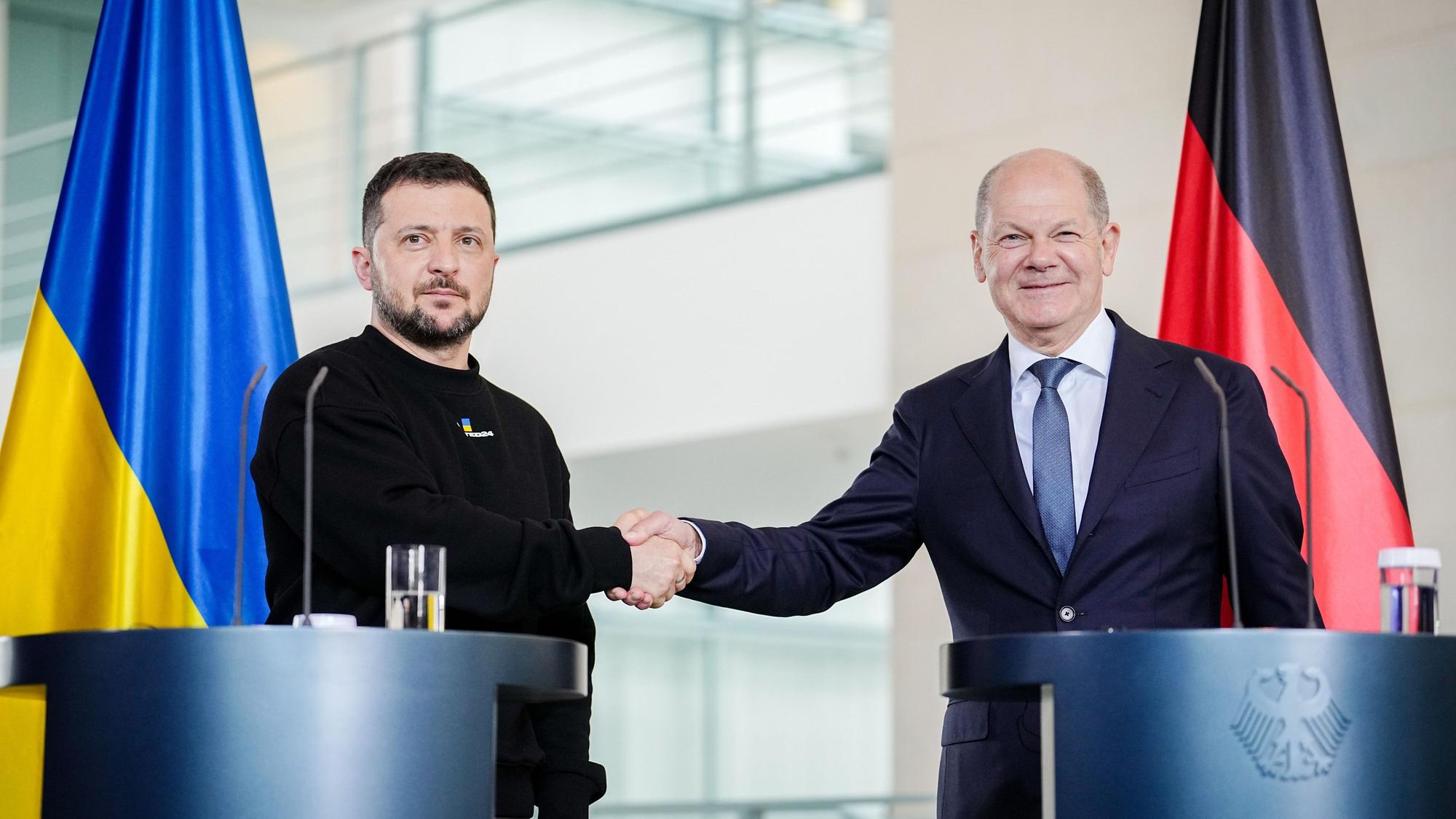 Wolodymyr Selenskyj, Präsident der Ukraine, und Bundeskanzler Olaf Scholz (r, SPD) geben sich bei einer Pressekonferenz nach ihrem Gespräch im Bundeskanzleramt die Hand.